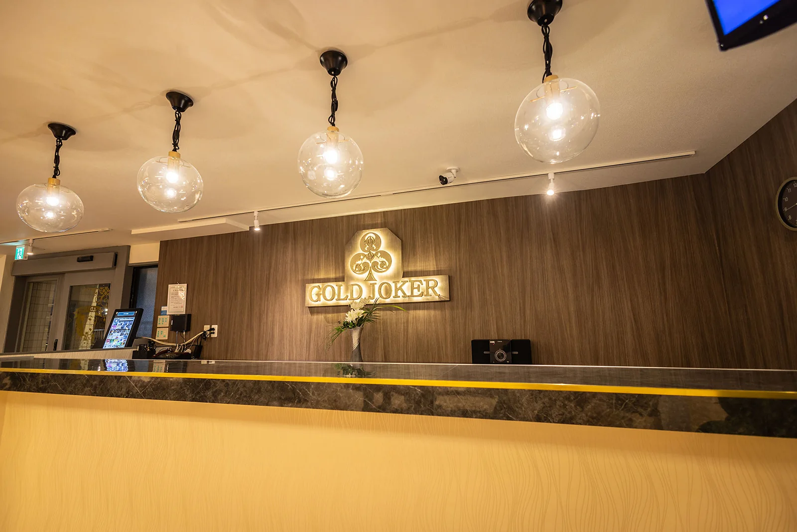 横浜ポーカーBar GOLD JOKER 相模原店の店内のカウンターとロゴ壁