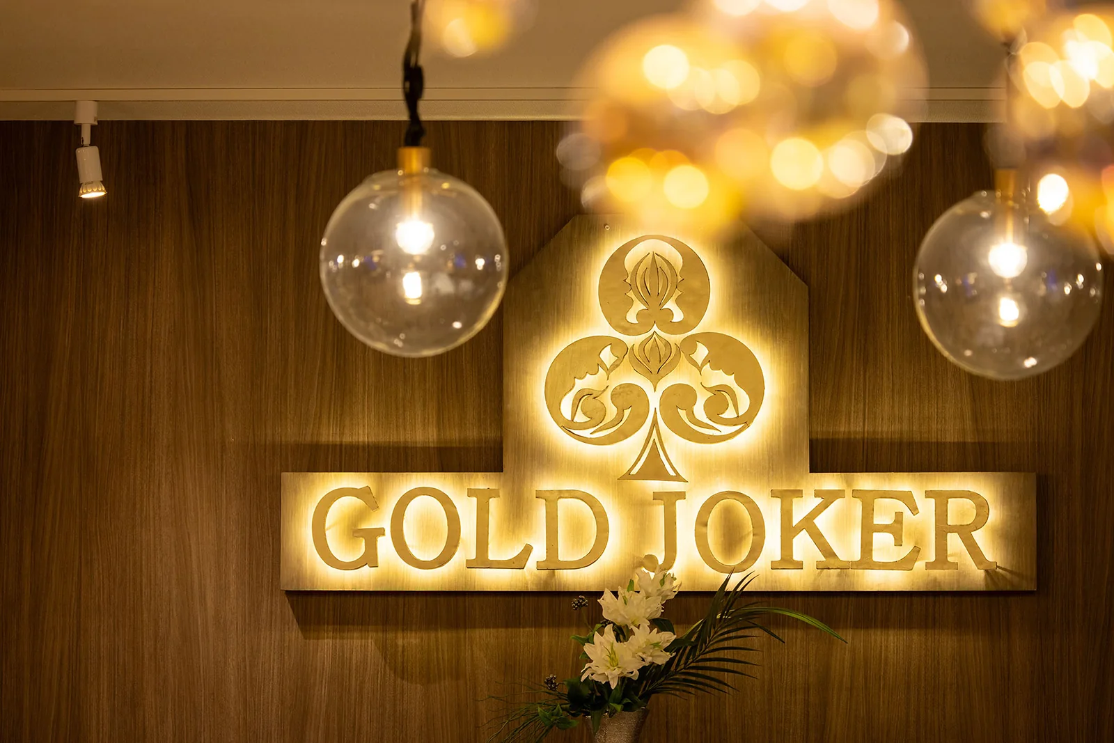 横浜ポーカーBar GOLD JOKER 相模原店の店内の照明とGOLD JOKERサイン